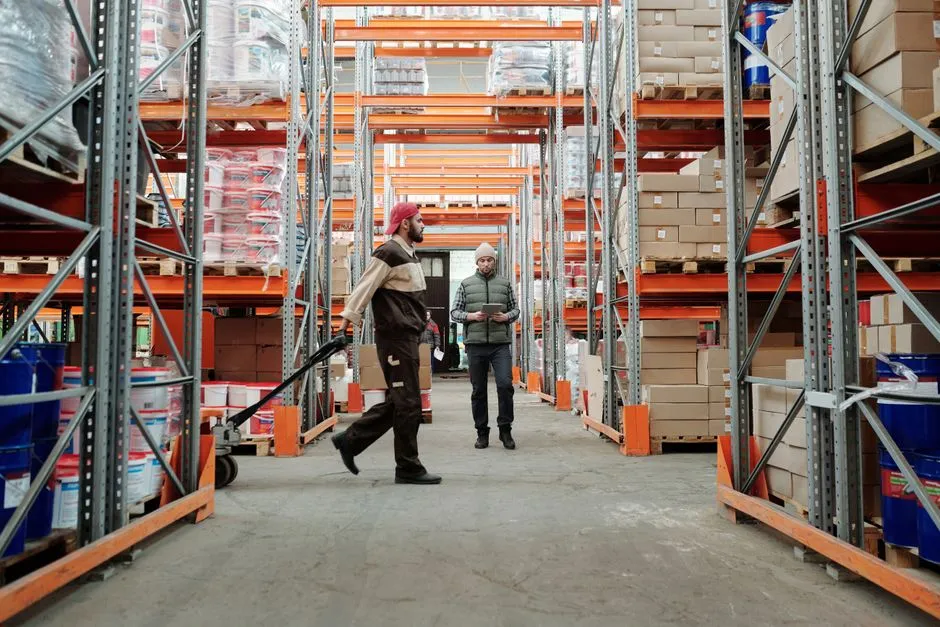 Deux intérimaires dans l'allée d'un entrepôt logistique