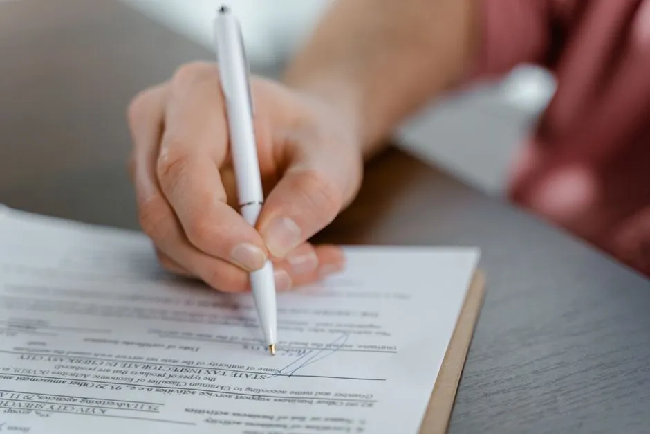 Main qui signe un document au stylo