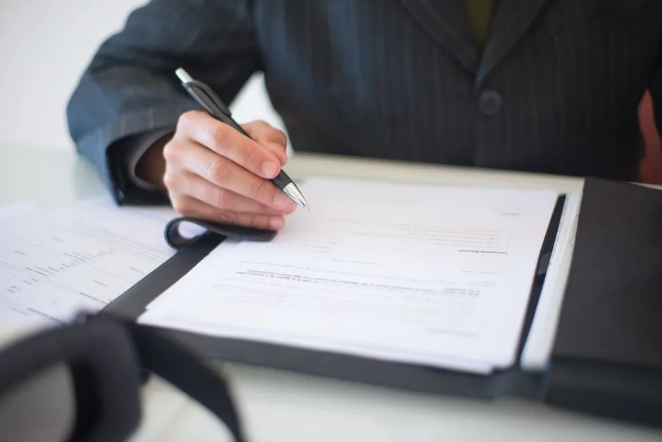 Signature d'un document posé dans un porte-documents
